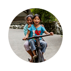Photo of two girls riding a bicycle